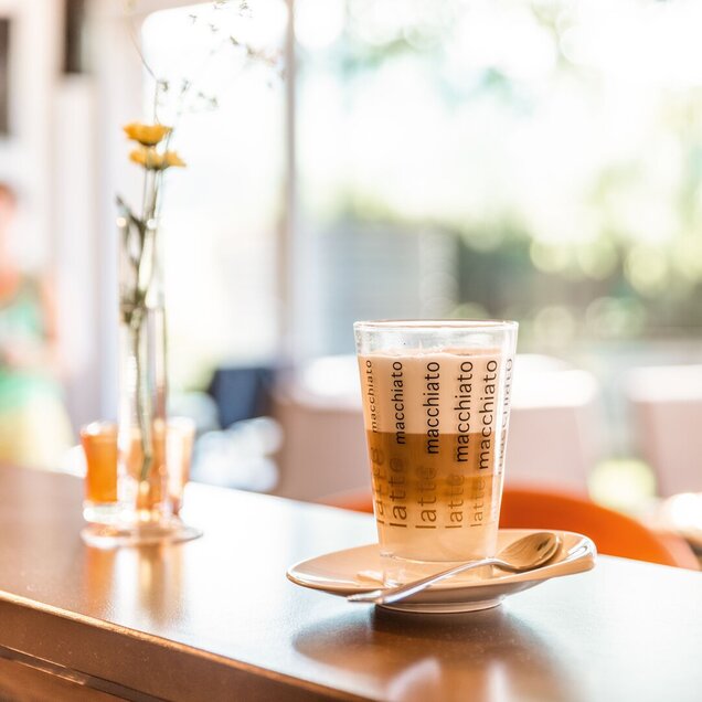 Kaffee auf der Theke in der Lounge mit einer Blume in einer Vase daneben. Kaffee auf der Theke in der Lounge
